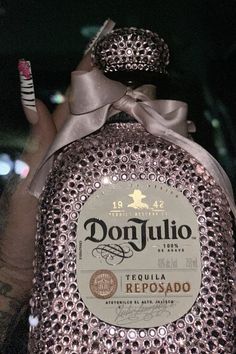 a bottle that has some kind of stuff on it's head and is covered in sequins