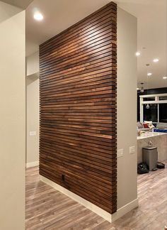 an empty room with wood slats on the wall and hard wood flooring in it