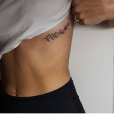 a woman's stomach with a small tattoo on her lower back and the bottom part of her body