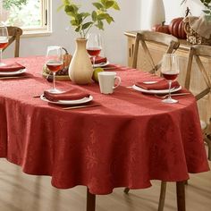 a dining table with red linens and place settings