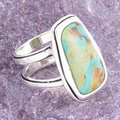 Indulge in the exquisite beauty of blue turquoise, encased in a sleek sterling silver bezel in an elegant rectangular form. The smooth cut of the turquoise radiates boldness, making this statement ring a must-have accessory. With a length of 1.1" and width of .6", this ring is weighty at 13.4 grams, exuding a sense of luxury and quality. The perfect fusion of turquoise and sterling silver, crafted and finished by skilled hands, elevates this piece to a true work of art. Turquoise Description: Tu Statement Ring Silver, Art Blue, Blue Turquoise, Turquoise Sterling Silver, Turquoise Blue, Statement Ring, Aqua Blue, Ring Necklace, Green Color