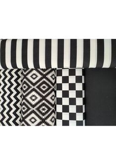 four different black and white patterns on the back of a couch with a pillow in front of it