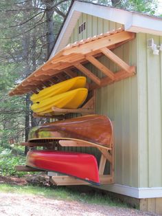 canoes are stored on the side of a shed