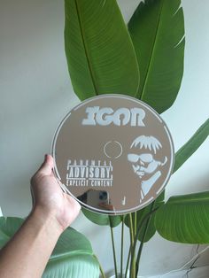 a person holding up a disc with an image of a man's face on it