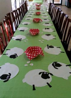 the table is set with paper plates and bowls for sheep themed party food, along with red gingham napkins