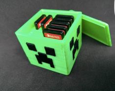 a green minecraft money box sitting on top of a black table next to a computer mouse