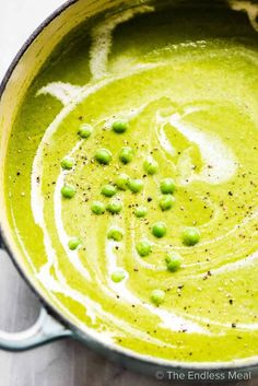 a pot filled with green pea soup on top of a table