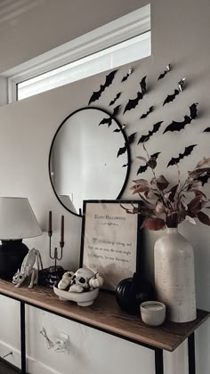 a table topped with a vase filled with flowers and bats on the wall behind it