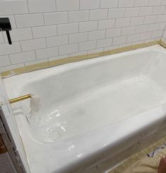 a person laying on the ground in front of a bathtub that is being remodeled