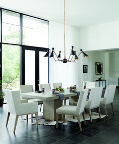 a dining room table with white chairs and a chandelier hanging from the ceiling