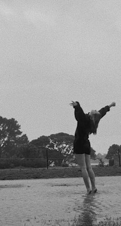 a person jumping in the air while holding onto a frisbee on a wet surface