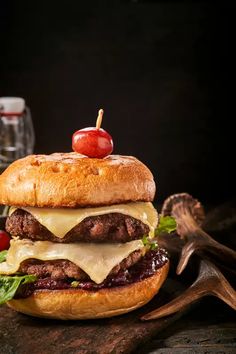 a cheeseburger with meat, tomato and lettuce