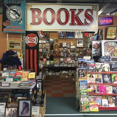 the inside of a book store with many books on display and signs in front of it