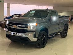 a silver truck is parked in a showroom