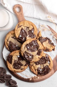 chocolate chip cookies with sea salt and milk on a wooden platter next to a glass of milk