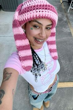 a woman wearing a pink and white crocheted hat on top of her head