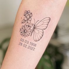 a small tattoo with a butterfly and flowers on the arm that reads, birth date