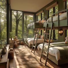 bunk beds in a room with windows overlooking the woods and trees, along with a rug on the floor