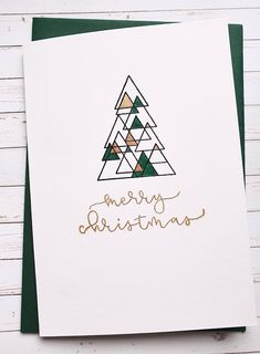 a card with a christmas tree on the front and merry christmas written in gold ink