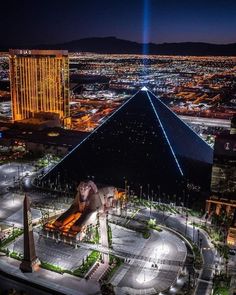 an aerial view of the pyramid and surrounding buildings at night with lights in the sky