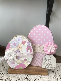 some pretty pink and white items on top of a doily covered table with a tag