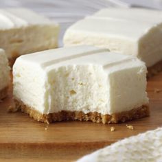 several pieces of cheesecake sitting on top of a wooden cutting board