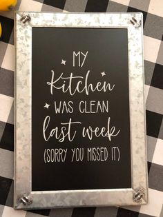 a black and white checkered table cloth with a chalkboard saying my kitchen was clean last week sorry you missed it