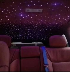 the interior of a car with stars on the ceiling and red leather seats in front