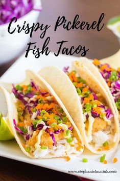 three fish tacos on a plate with cole slaw