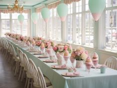 a long table is set with pink and white flowers, ice cream cones, and balloons