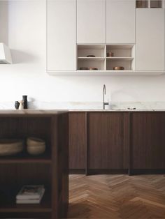 a kitchen with wooden floors and white cabinets