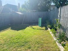 a backyard with a fence and green yard