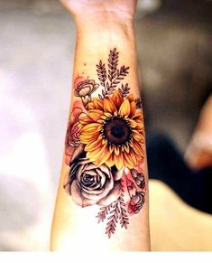 a woman's arm with a sunflower and roses tattoo on the left wrist