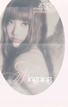 a girl with long brown hair and bangs in front of a white circular sign that says ingging