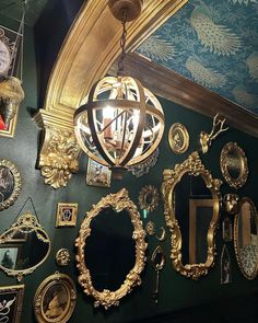 there are many mirrors on the wall with gold trimmings and ornate frames around them