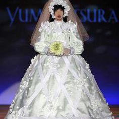 a woman in a white wedding dress on a runway