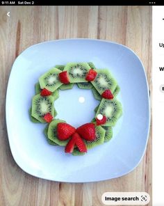 a white plate topped with kiwi slices and strawberries