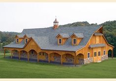 a large wooden building sitting on top of a lush green field