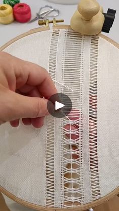 a person is stitching on a piece of fabric