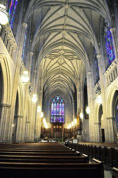 the inside of a church with pews and stained glass windows