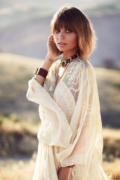 a woman in a white dress is posing for a photo with her hand on her head