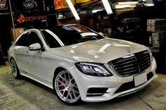 a white mercedes s - class parked in a garage