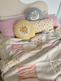 a quilted bed with pillows on it and a pillow in the corner next to it