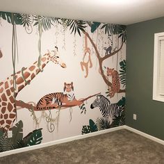 a room with a wall mural featuring giraffes and zebras