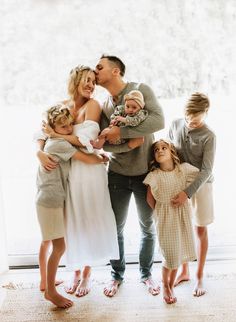 a family posing for a photo in front of a window