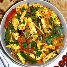 a bowl filled with tofu and veggies on top of a white table