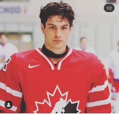 a young man in a red jersey is looking at the camera