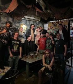 a group of people posing for a photo in a room with stone walls and ceilings