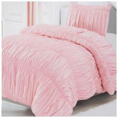 a pink comforter set with ruffles on it