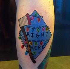 a tattoo on the leg of a person with a hammer and christmas lights around it